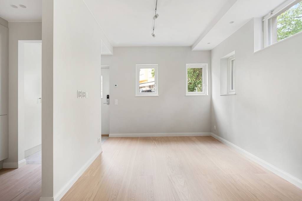 Överblick av allrummet som visar takhöjden och den moderna spårbelysningen i taket.