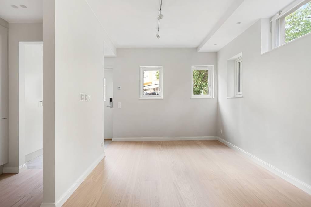 Överblick av allrummet som visar takhöjden och den moderna spårbelysningen i taket.